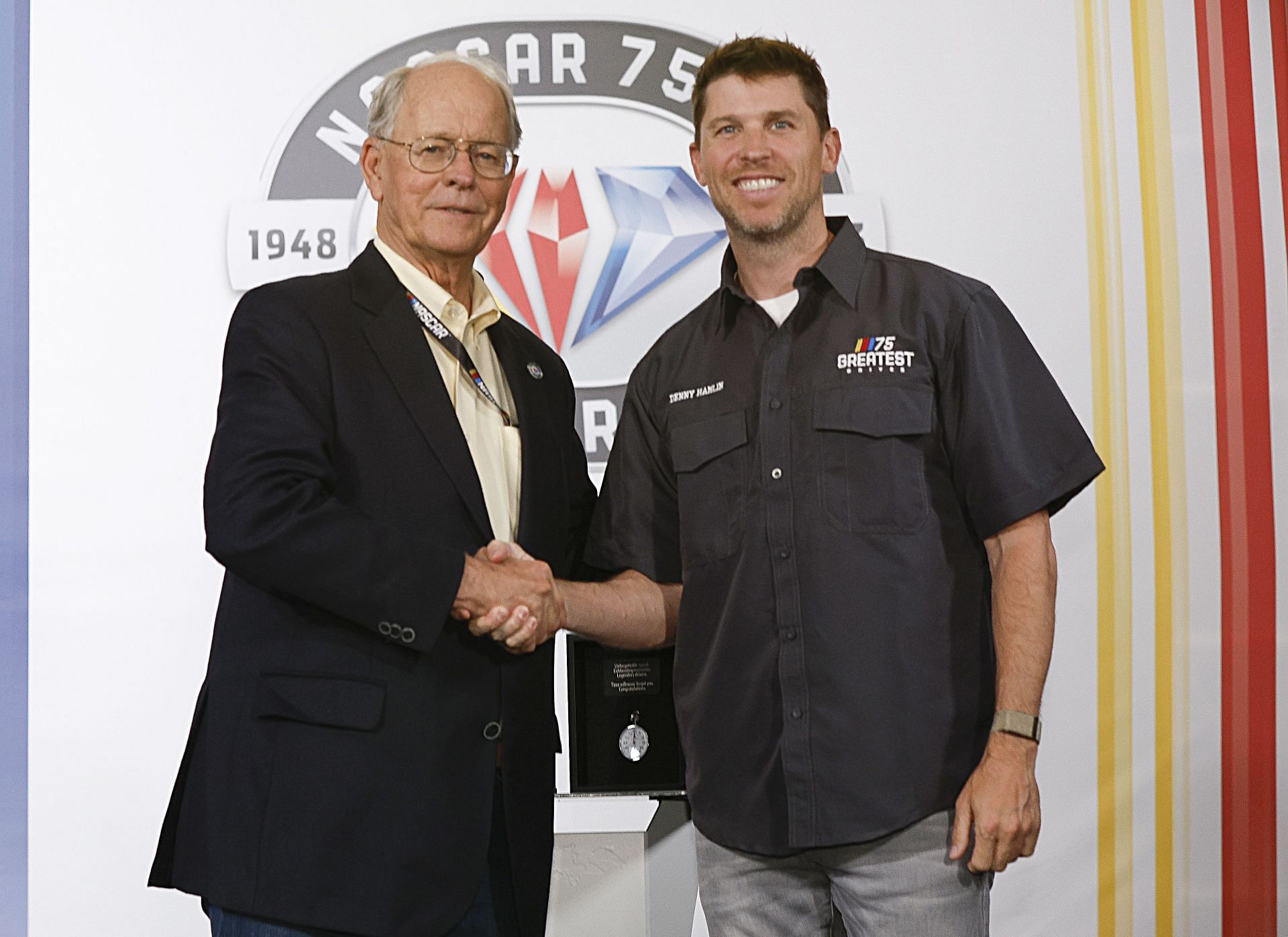 NASCAR Chairman Jim France (L) congratulates Denny Hamlin on selection to NASCAR's 75 Greatest Drivers list. Source: Getty